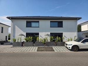 a white car parked in front of a white house at Apartment Schlossterrassen 8a in Pouch