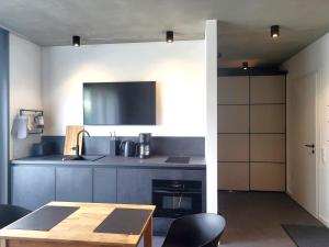 a kitchen with a table and a tv on the wall at Apartment Schlossterrassen 8a in Pouch +29 photos