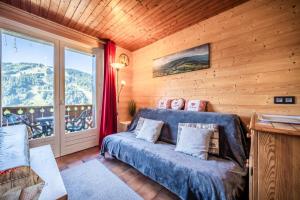 a living room with a blue couch and a window at Chalet Arnica in Morzine