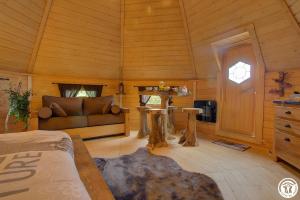 a room with a couch and a table in a cabin at Chambre Insolite L'écureuil in Coligny