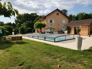 a swimming pool in a yard next to a house at Chambre Insolite L'écureuil in Coligny