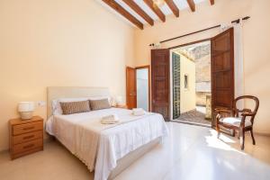 a bedroom with a bed and a chair and a window at Cas Sitger in Felanitx