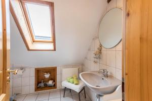 a bathroom with a sink and a mirror and a window at Ferienwohnung Adler in Wirdum +19 photos