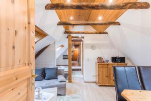 a living room with a blue couch and wooden ceilings at Ferienwohnung Adler in Wirdum