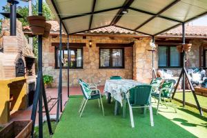 a patio with a table and chairs under a roof at La Casa del Carpintero in Zarapicos