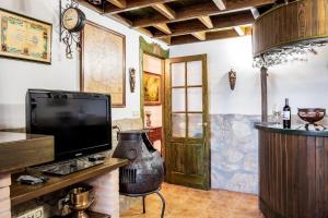 a living room with a tv and a door at La Casa del Carpintero in Zarapicos