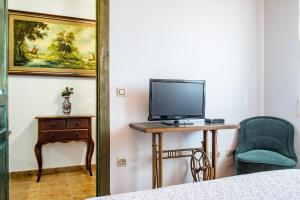 a bedroom with a desk with a tv and a chair at La Casa del Carpintero in Zarapicos