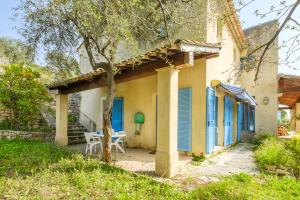 a house with blue doors and a table in the yard at Appartement Numéro 1 - piscine in Valbonne