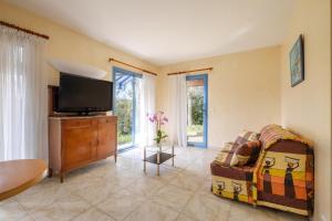 a living room with a couch and a flat screen tv at Appartement Numéro 1 - piscine in Valbonne
