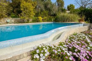 a swimming pool in a garden with flowers at Appartement Numéro 1 - piscine in Valbonne