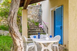 a white table and chairs on a patio with a blue door at Appartement Numéro 1 - piscine in Valbonne