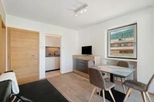 a living room with a table and chairs and a kitchen at Premium App Hofer Barbara in Villabassa