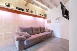 a couch in a room with a brick wall at Finca Can Menut in Felanitx