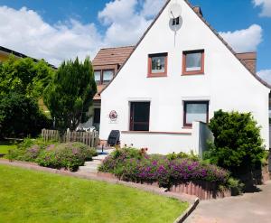a white house with flowers in front of it at Ostseekind in Timmendorfer Strand