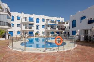 a swimming pool in front of a building at Brisa del Puerto de la Duquesa in Manilva