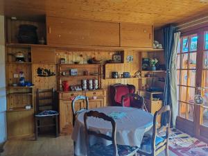 a dining room with a table and chairs in a room at Chalet Vététiste in Laveissière