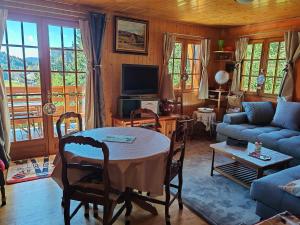 a living room with a table and a couch at Chalet Vététiste in Laveissière