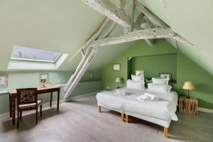 a attic bedroom with a bed and a desk at La Petite Trigalière in Ambillou +37 photos