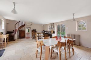 a kitchen and dining room with a table and chairs at La Petite Trigalière in Ambillou