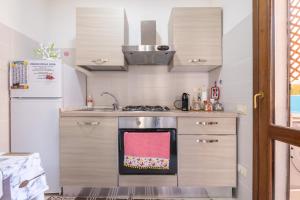 a small kitchen with a stove and a refrigerator at Queen's House in Pula