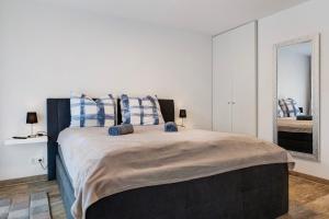 a bedroom with a large bed with blue and white pillows at Ferienwohnung Santa Gabriella in Herbolzheim