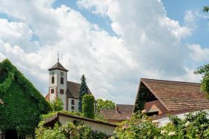 a building with a tower with a cross on it at Ferienwohnung Santa Gabriella in Herbolzheim