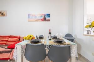 a dining room table with chairs and a bottle of wine at Queen's House in Pula