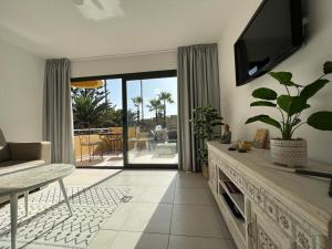 a living room with a tv and a couch and a table at CasaFelix in Corralejo