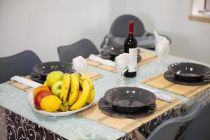 a table with a bowl of fruit and a bottle of wine at Queen's House in Pula