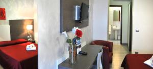 a hotel room with a table with a vase of flowers at Hotel Venezia in Caorle