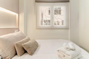 a bedroom with a bed with towels and a window at Cala Azul-few steps from the beach in La Cala de Mijas