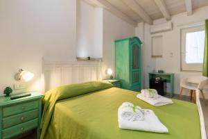 a bedroom with a green bed with towels on it at Chibao House con piscina privata in Ragusa +18 photos