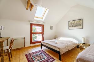 a bedroom with a bed and a window and a desk at Bnb Au Petit Ruisseau in Plobsheim