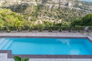 a swimming pool with a mountain in the background at Chibao House con piscina privata in Ragusa