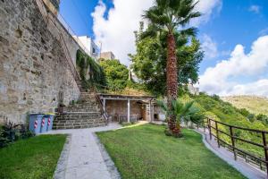 a palm tree in front of a building with stairs at Chibao House con piscina privata in Ragusa