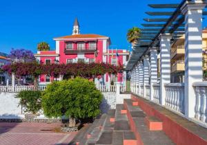 a pink building with trees in front of it at Estudio Bibi in El Paso