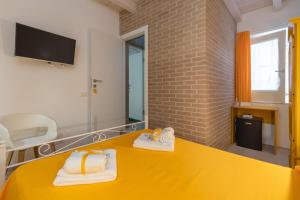 a room with a yellow table with towels on it at Chibao House con piscina privata in Ragusa