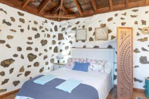 a bedroom with a bed and a wall with rocks at Estudio Bibi in El Paso