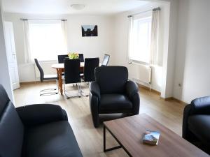 a living room with black chairs and a table at Ferienhaus Drelsdorfer Forst in Drelsdorf