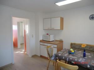 a kitchen and dining room with a table and a microwave at Ferienhaus Drelsdorfer Forst in Drelsdorf
