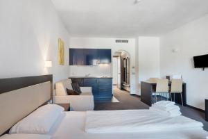 a bedroom with a bed and a living room with a kitchen at Residence Alpenrose in Col di Villa