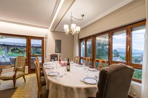 a dining room with a table and chairs and windows at Casa La Quinta in Colindres