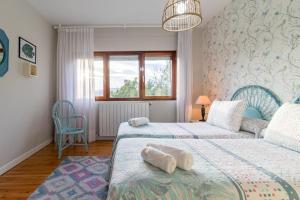 a bedroom with two beds and a window at Casa La Quinta in Colindres +22 photos