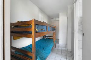 a bunk bed in a small room with blue sheets at Appartement du Golf - Pornic 2 in Pornic
