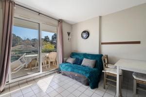 a living room with a couch and a balcony at Appartement du Golf - Pornic 2 in Pornic +12 photos
