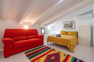 a living room with a red couch and a bed at Casa Sorteta, en el centro de Artà in Artá