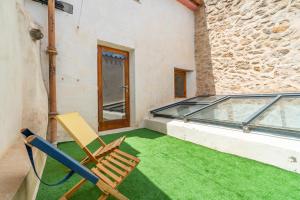a patio with two chairs and a glass balcony at Casa Sorteta, en el centro de Artà in Artá