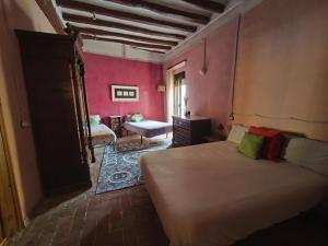 a bedroom with a bed in a room with pink walls at Ca l'Aleixa Rooms in Bisbal de Falset