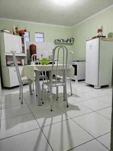 a kitchen with a table and chairs and a refrigerator at Flats Xingó in Piranhas