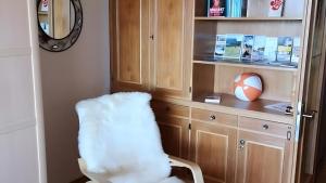 a room with a chair and a book shelf at Appartement Simonhöhe mit Pool in Zirkitz +12 photos